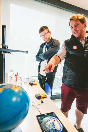 Two mean look towards a globe at the Dyson challenge day with Challenger Escapes