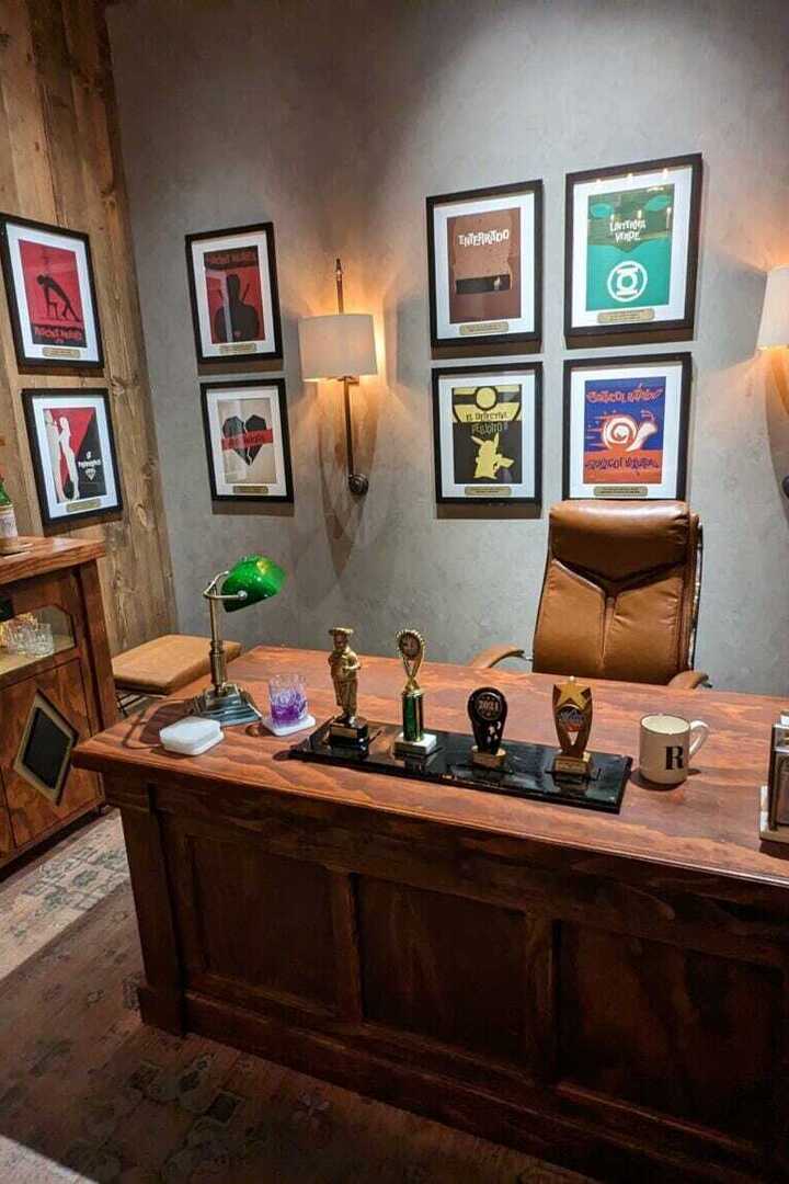 Interactive escape room featuring an office with a wooden desk, chair, and framed artwork